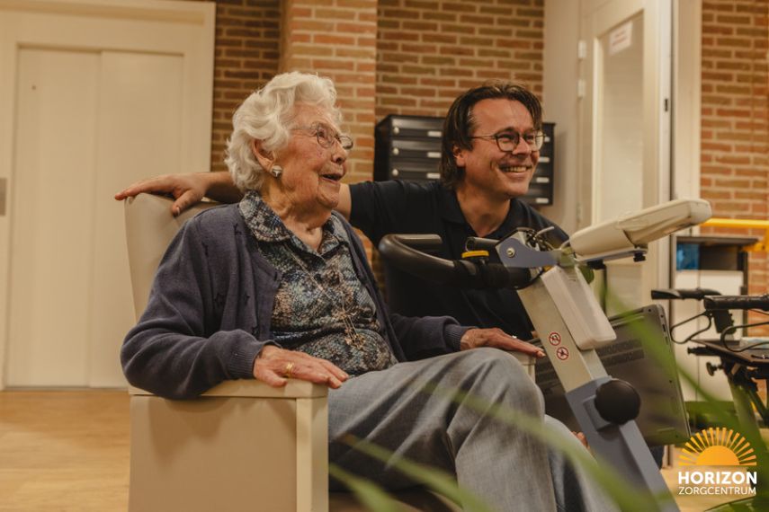 Bewoner neemt deel aan een activiteit met begeleiding van een medewerker