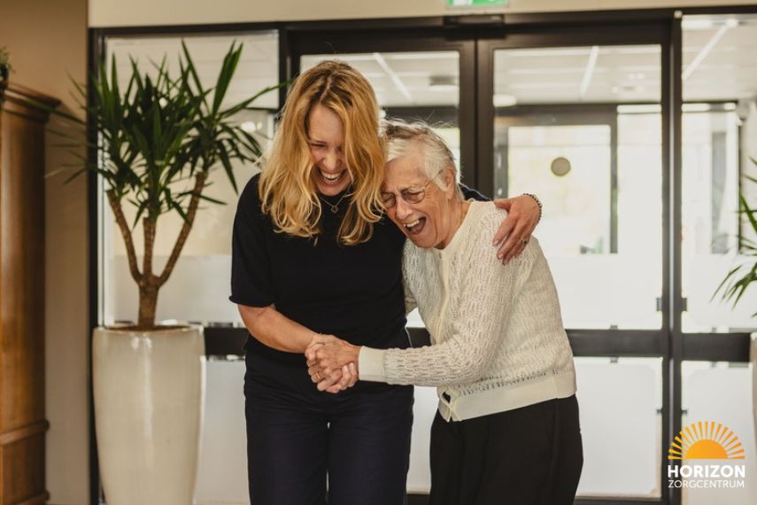 Bewoner en medewerker delen een vrolijk moment bij Horizon Zorgcentrum